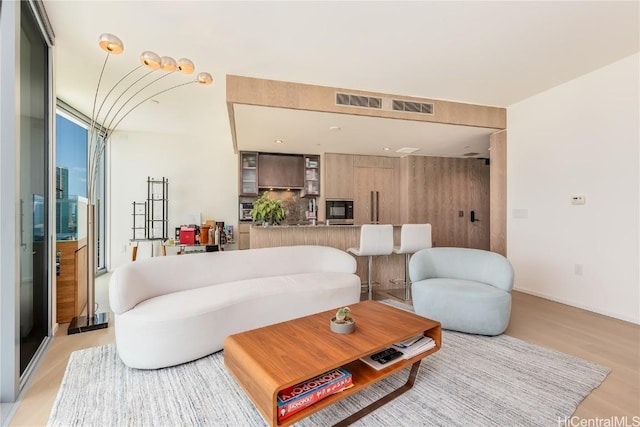 living room with light wood-style flooring and visible vents