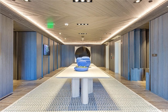 hall with wooden ceiling, wooden walls, and recessed lighting