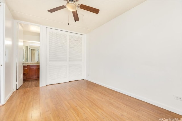 unfurnished bedroom featuring light wood finished floors, a closet, connected bathroom, ceiling fan, and baseboards