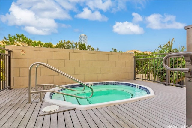 view of pool featuring a wooden deck and a hot tub