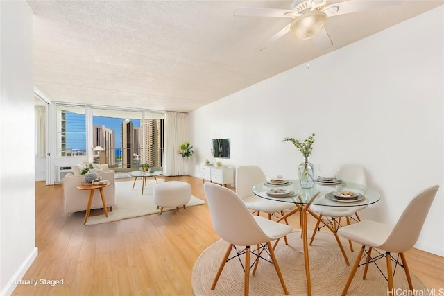 dining room with a ceiling fan, a textured ceiling, and wood finished floors