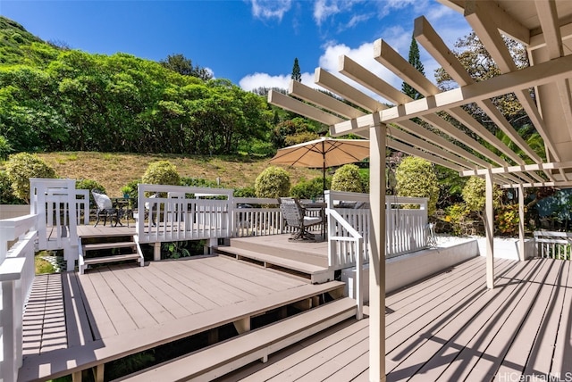 wooden deck with a pergola and outdoor dining area