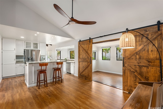 914 Kahena St, Honolulu, HI 96825 - kitchen featuring a barn door, appliances with stainless steel finishes, a breakfast bar, a ceiling fan, and glass insert cabinets