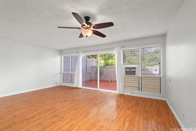 empty room with a ceiling fan, a textured ceiling, baseboards, and wood finished floors