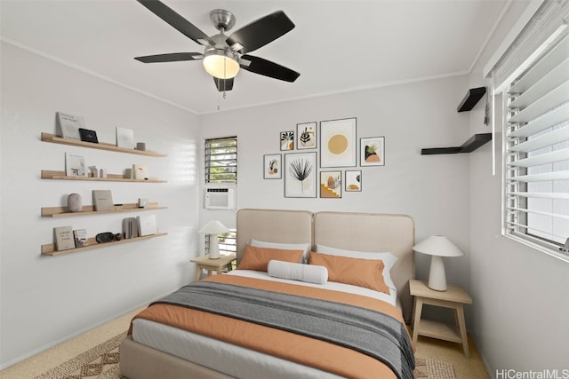 carpeted bedroom with ceiling fan, baseboards, and crown molding