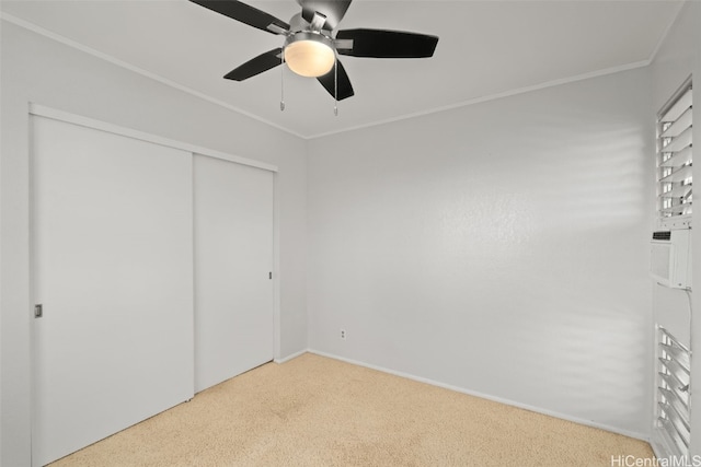 unfurnished bedroom featuring a ceiling fan, a closet, crown molding, and baseboards