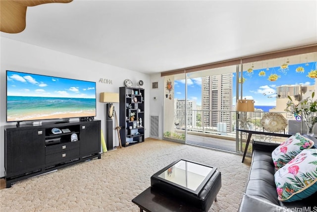 carpeted living room with expansive windows, a view of city, and visible vents