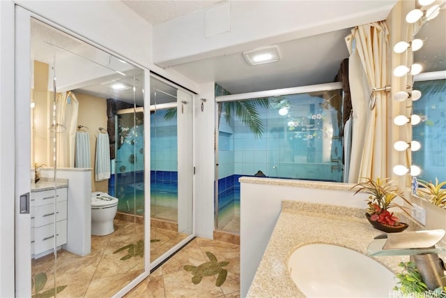 bathroom featuring toilet, a shower stall, and vanity