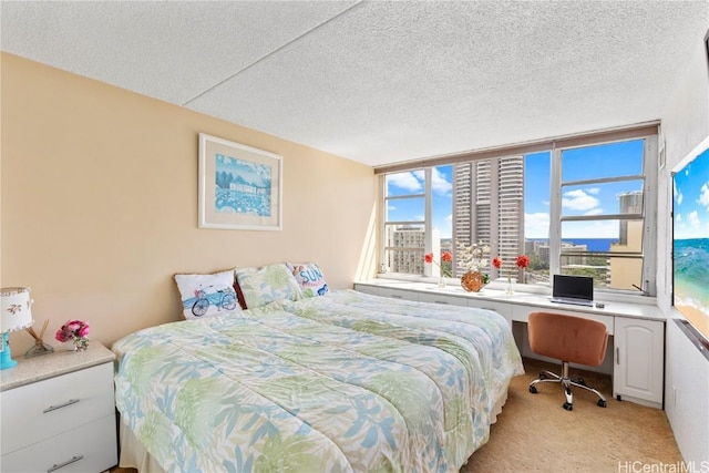 bedroom featuring a textured ceiling, built in desk, and light colored carpet