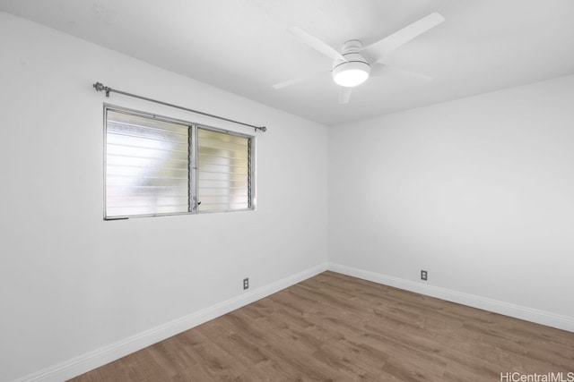 spare room featuring ceiling fan, baseboards, and wood finished floors