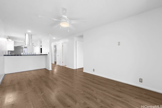 unfurnished living room featuring a ceiling fan, recessed lighting, wood finished floors, and baseboards