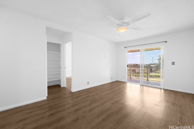 unfurnished room featuring ceiling fan, baseboards, built in features, and wood finished floors