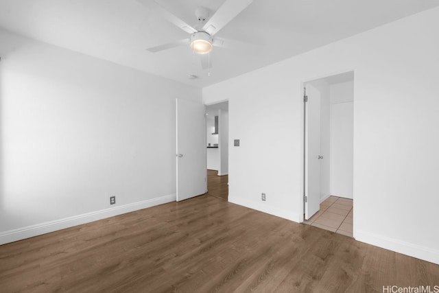 spare room featuring baseboards, ceiling fan, and wood finished floors