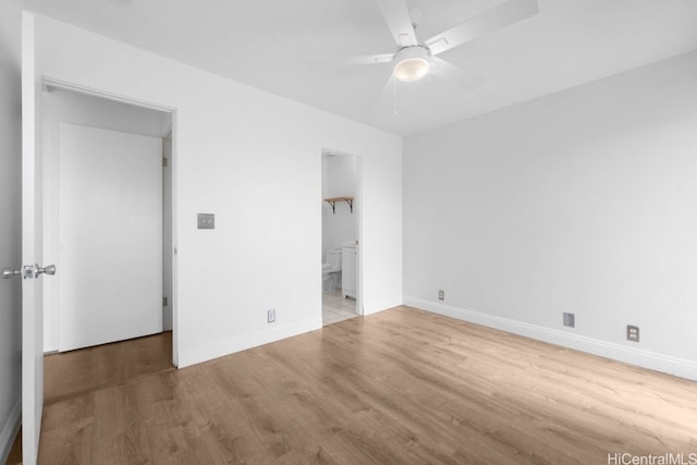 unfurnished bedroom with ceiling fan, ensuite bath, baseboards, and wood finished floors