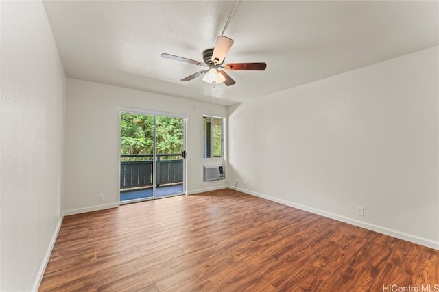 unfurnished room with a ceiling fan, baseboards, wood finished floors, and an AC wall unit