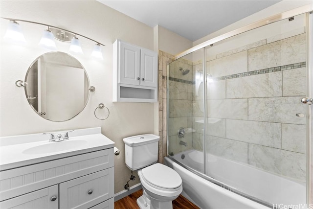 bathroom featuring combined bath / shower with glass door, vanity, toilet, and wood finished floors