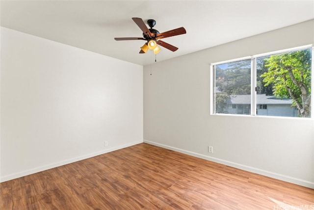 unfurnished room with ceiling fan, baseboards, and wood finished floors