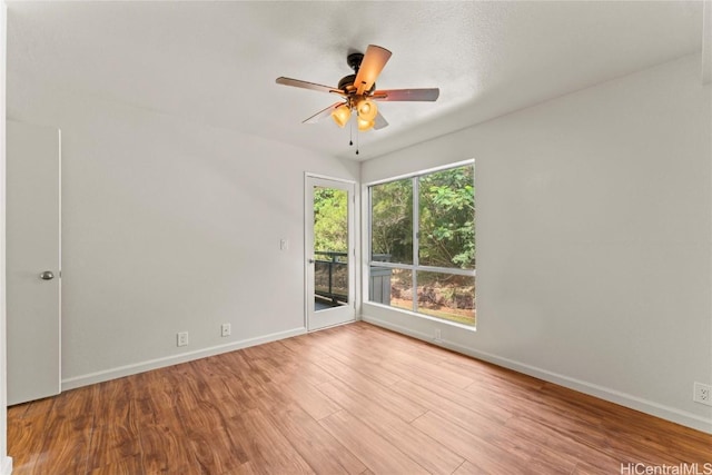 empty room with ceiling fan, baseboards, and wood finished floors