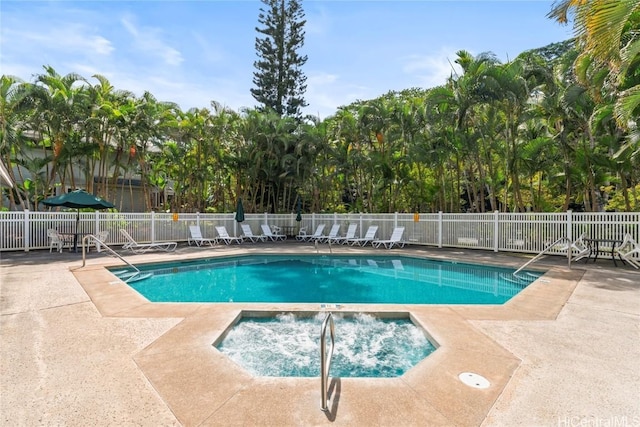 pool with fence, a hot tub, and a patio