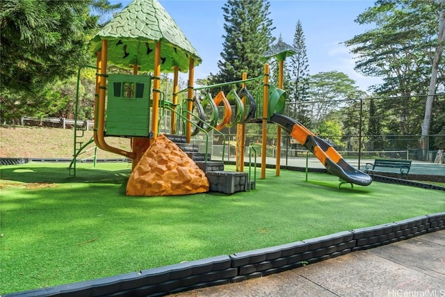 communal playground featuring fence and a lawn