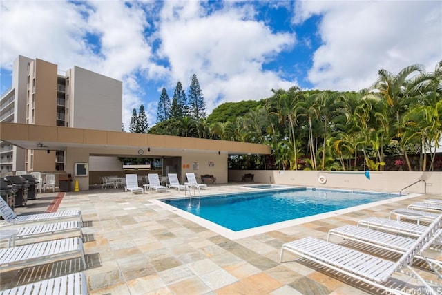 community pool featuring a patio, fence, and grilling area