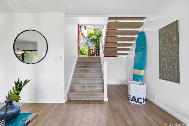 stairway with baseboards and wood finished floors