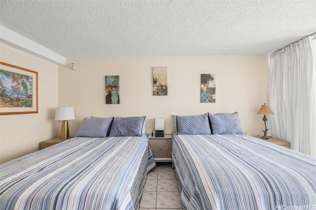 bedroom with a textured ceiling and light tile patterned flooring