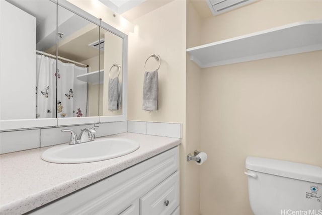 bathroom featuring curtained shower, visible vents, vanity, and toilet