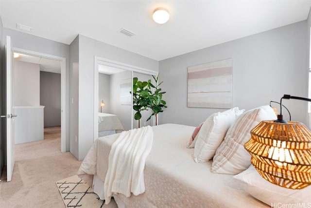 bedroom featuring visible vents and light carpet