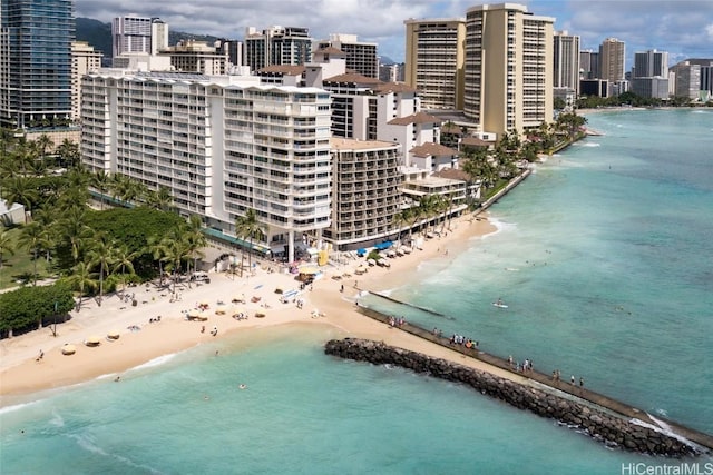 drone / aerial view with a city view, a water view, and a beach view