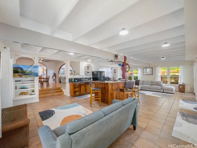 living room with beam ceiling and light tile patterned flooring