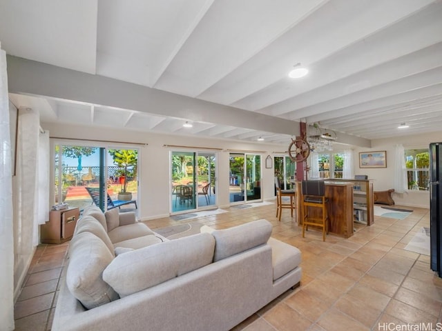 living area with light tile patterned floors, baseboards, and beamed ceiling