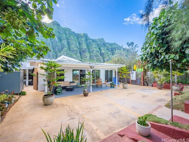 back of house featuring fence, outdoor lounge area, and a patio