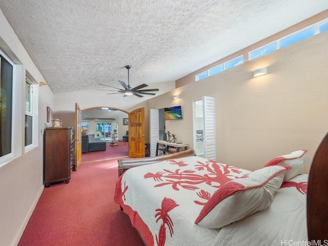 carpeted bedroom featuring lofted ceiling, multiple windows, arched walkways, and a textured ceiling