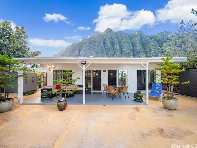 back of house with a patio, an outdoor structure, and an outdoor hangout area