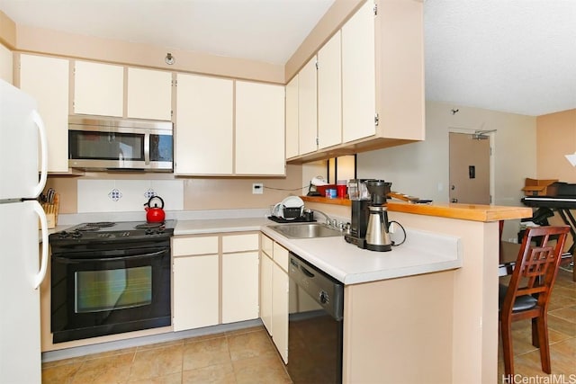 kitchen featuring black appliances, light tile patterned floors, light countertops, and a sink