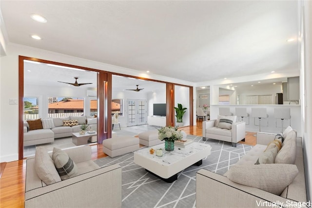 living area with ornamental molding, recessed lighting, and wood finished floors