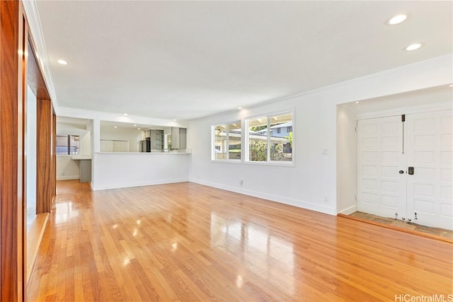 unfurnished living room featuring light wood-style floors, baseboards, crown molding, and recessed lighting