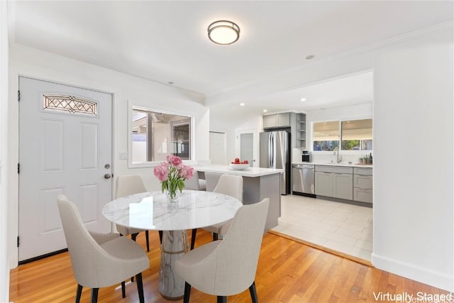 dining area featuring light wood finished floors, recessed lighting, and crown molding