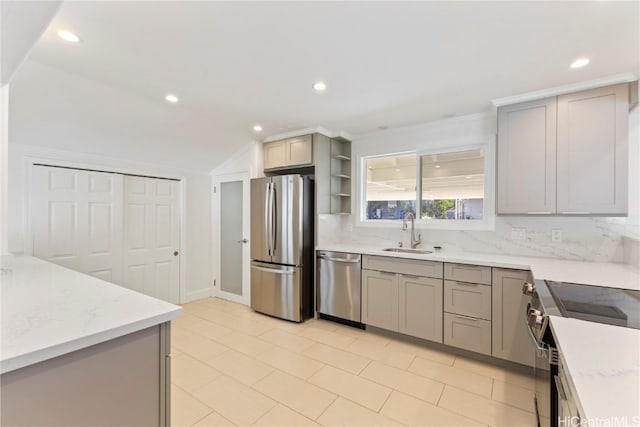 kitchen featuring appliances with stainless steel finishes, gray cabinetry, open shelves, a sink, and recessed lighting