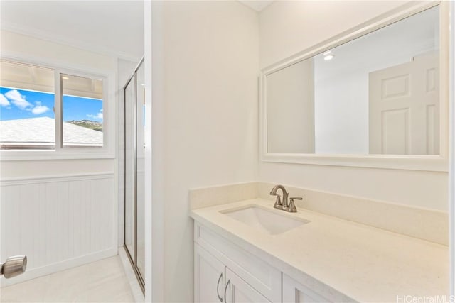 bathroom featuring a stall shower, wainscoting, and vanity