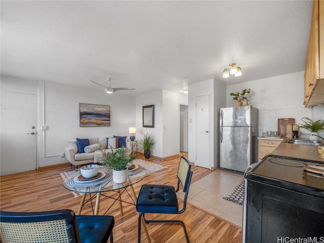 dining area with light wood-style flooring and a ceiling fan