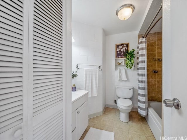 bathroom with toilet, tile patterned floors, shower / bath combo with shower curtain, vanity, and a closet