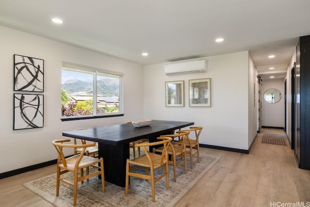 dining area featuring baseboards, a wall mounted AC, recessed lighting, and light wood-style floors