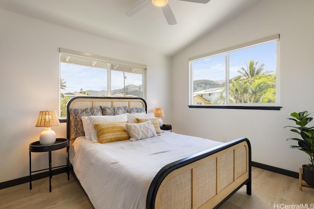 bedroom with a ceiling fan, vaulted ceiling, light wood-style flooring, and baseboards