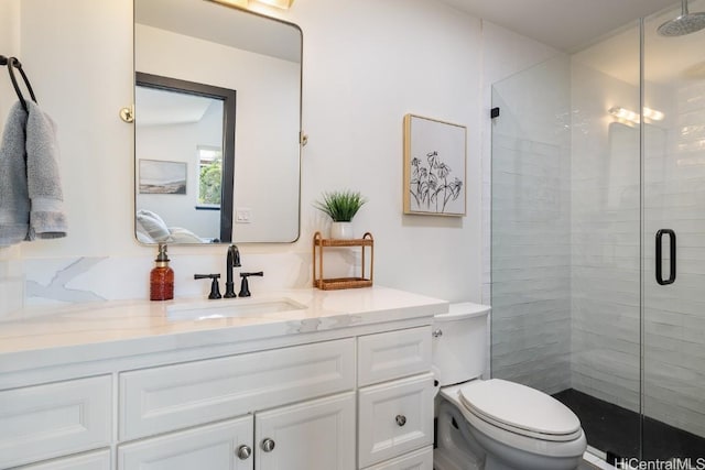 full bath with a stall shower, vanity, and toilet