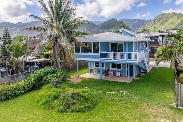 rear view of house featuring a lawn, a patio area, fence, a mountain view, and stairs