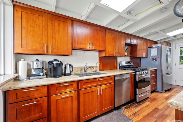 41-949 Laumilo St, Waimanalo, HI 96795 - kitchen featuring stainless steel appliances, a sink, light wood-style floors, beam ceiling, and brown cabinets
