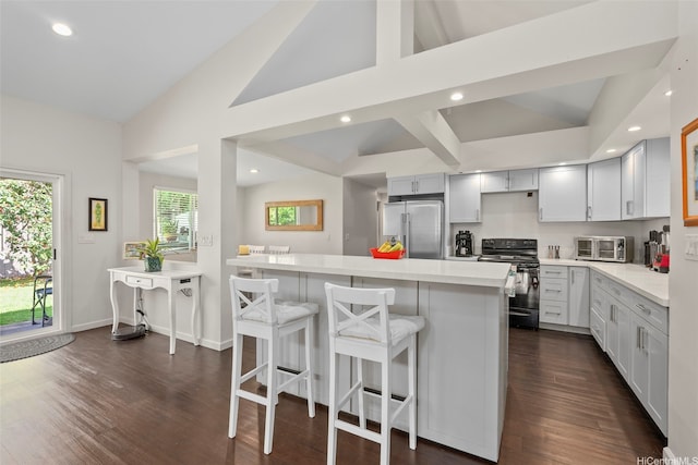 41-949 Laumilo St, Waimanalo, HI 96795 - kitchen with high quality fridge, black range with electric stovetop, vaulted ceiling, recessed lighting, and a kitchen bar