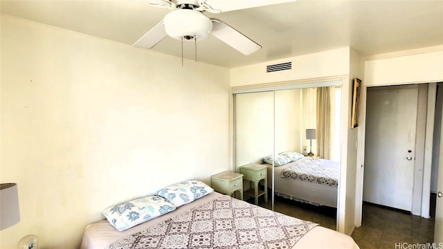 bedroom with dark tile patterned floors, visible vents, and a ceiling fan